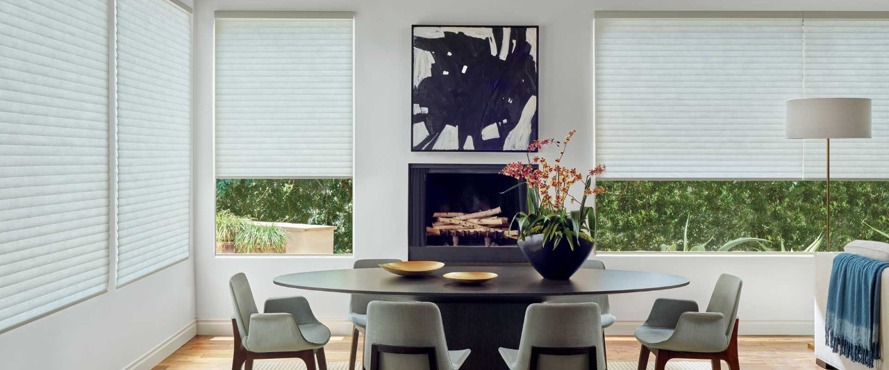 Dining room with black circular table and Sonnette shades.